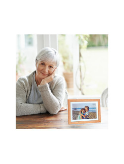 Ältere Dame erfreut sich am digitalen Bildrrahmen mit Motiv quer